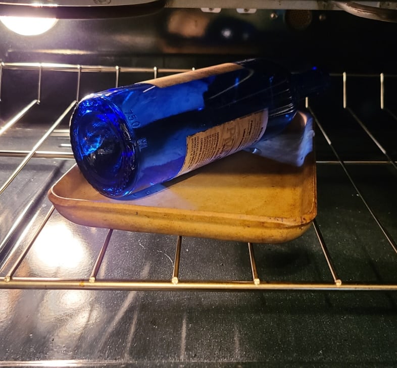 blue wine bottle on a dish in the oven