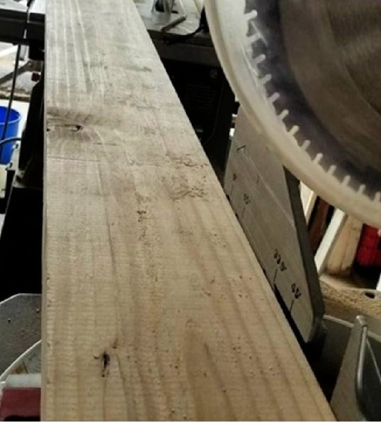 cut reclaimed fence board on miter saw