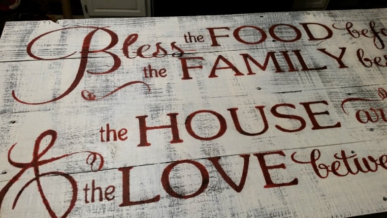 reveal of rustic sign with wax stenciled letters