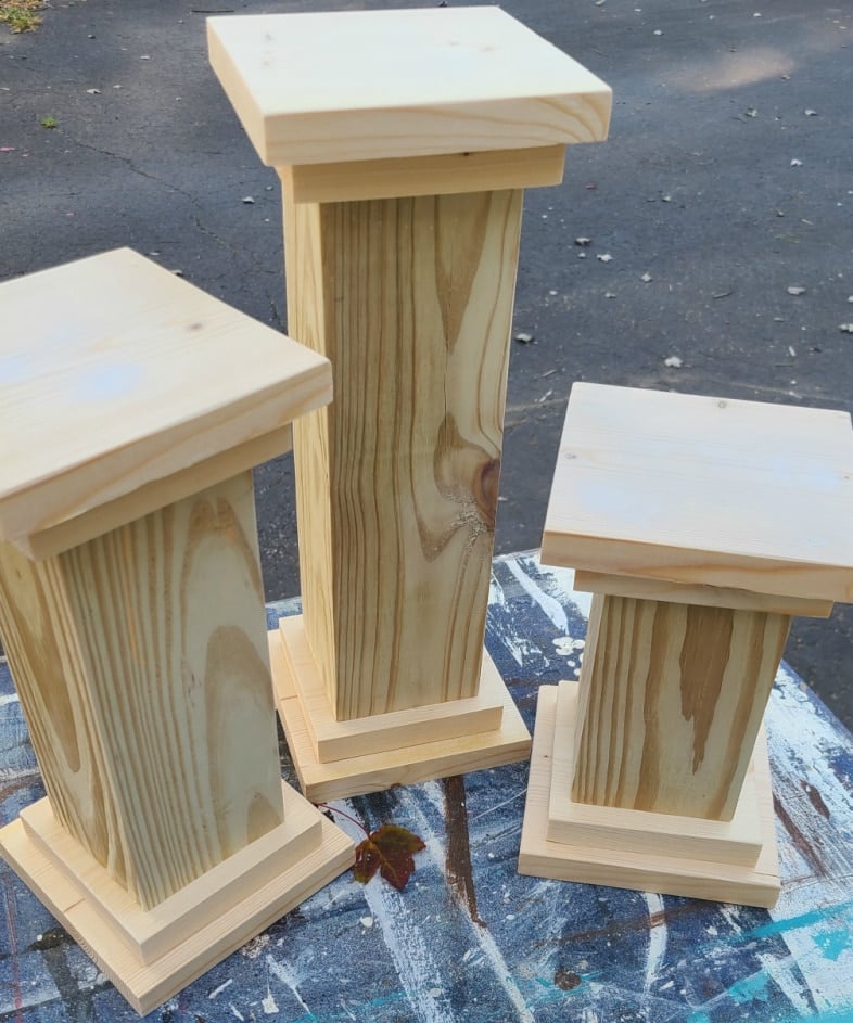three wooden pedestals with doube base