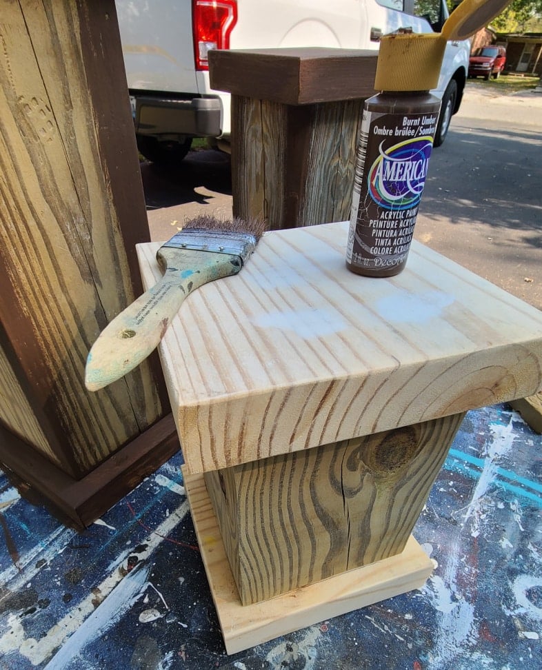chunky plant pedestal with a paint brush and umber paint bottle