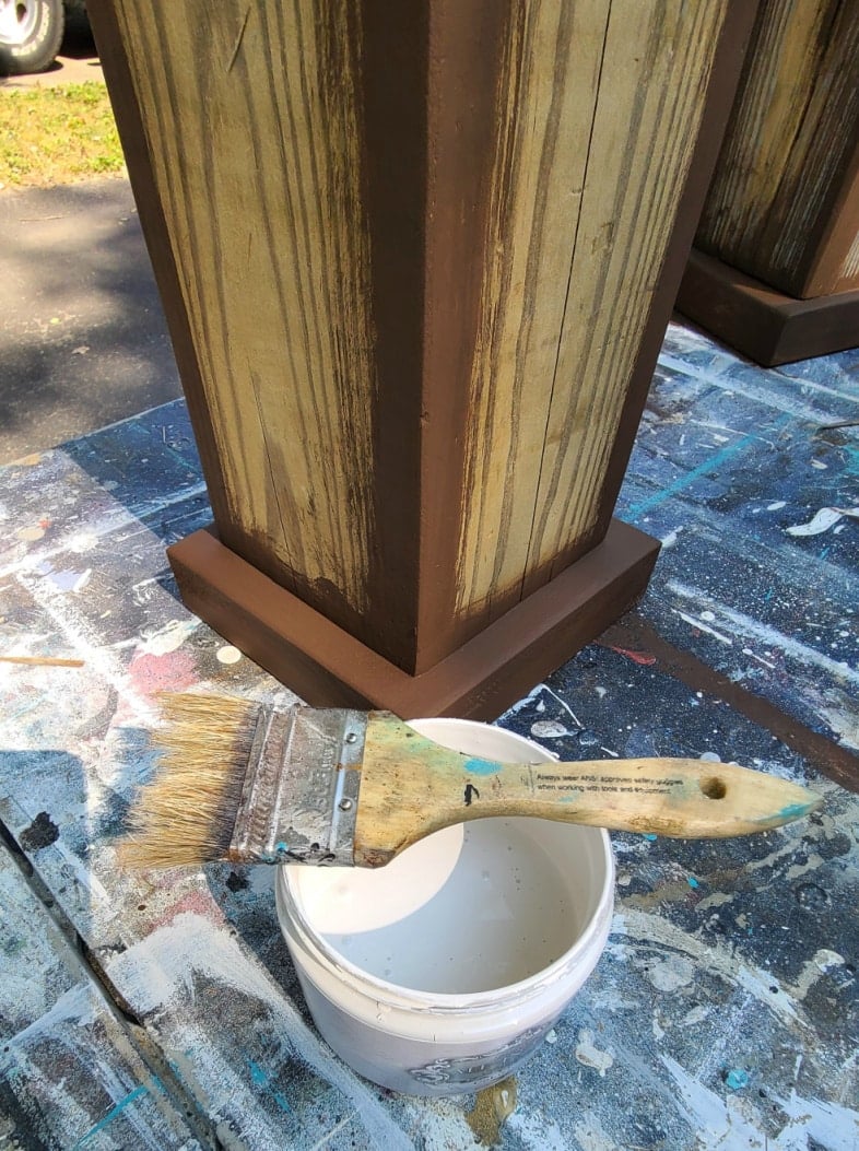 painting plant pedestals with dark paint on the corners