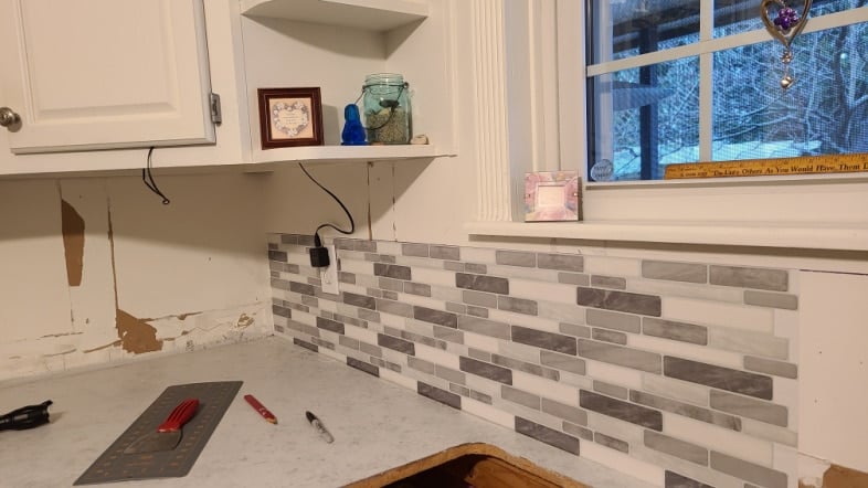 gray toned backsplash started in the corner
