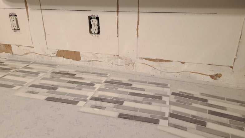old backsplash, peel and stick wallpaper laying on countertop