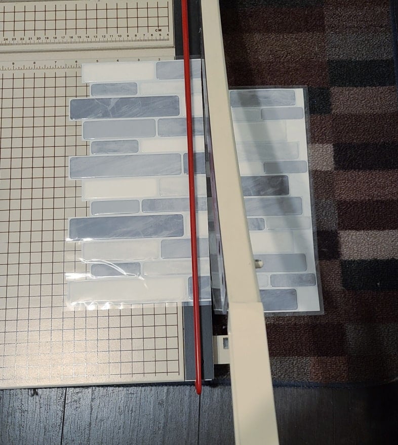 large paper cutter cutting peel and stick backsplash