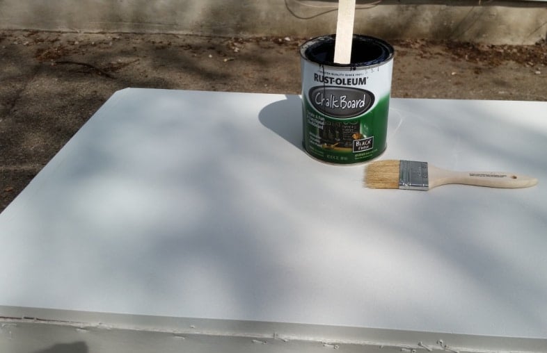 desktop with a can of chalkboard paint and a paintbrush