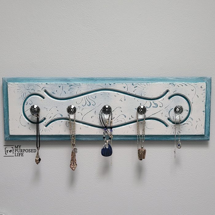 wooden jewelry organizer holding necklaces