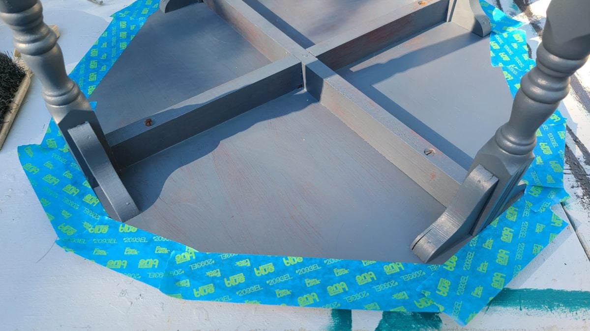 underside of table with blue painters tape