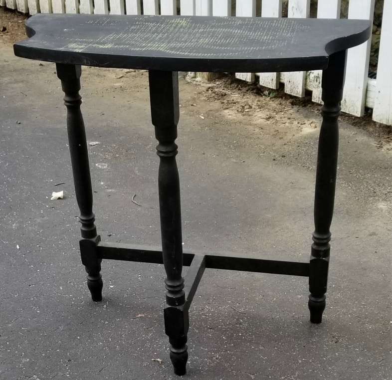 three legged dark table that needs painting