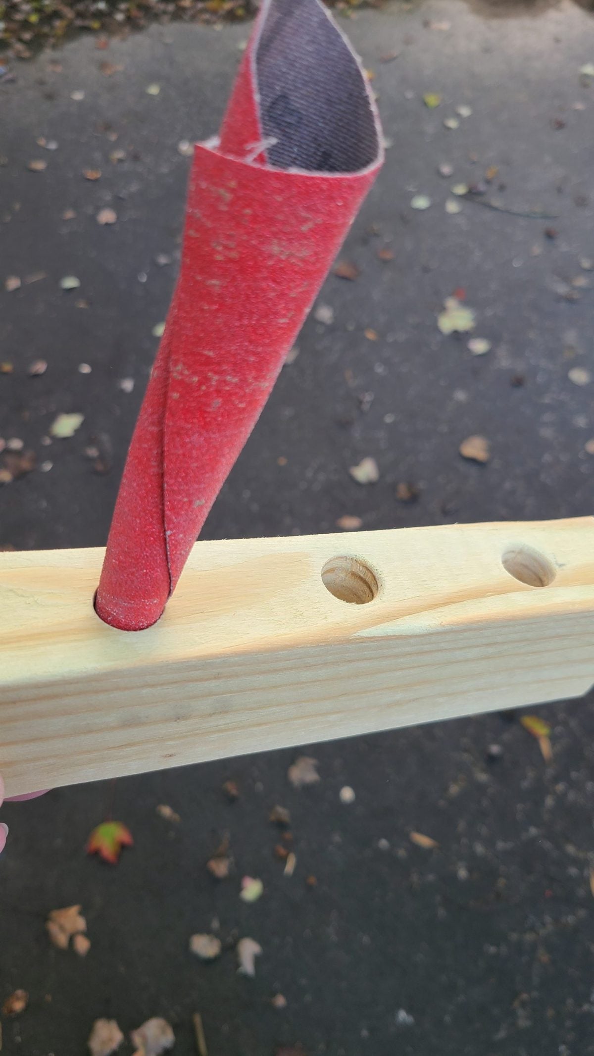 rolled-up sandpaper to smooth holes in wood