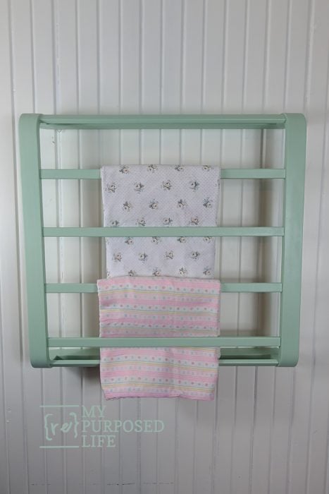 green blanket rack holding baby blankets