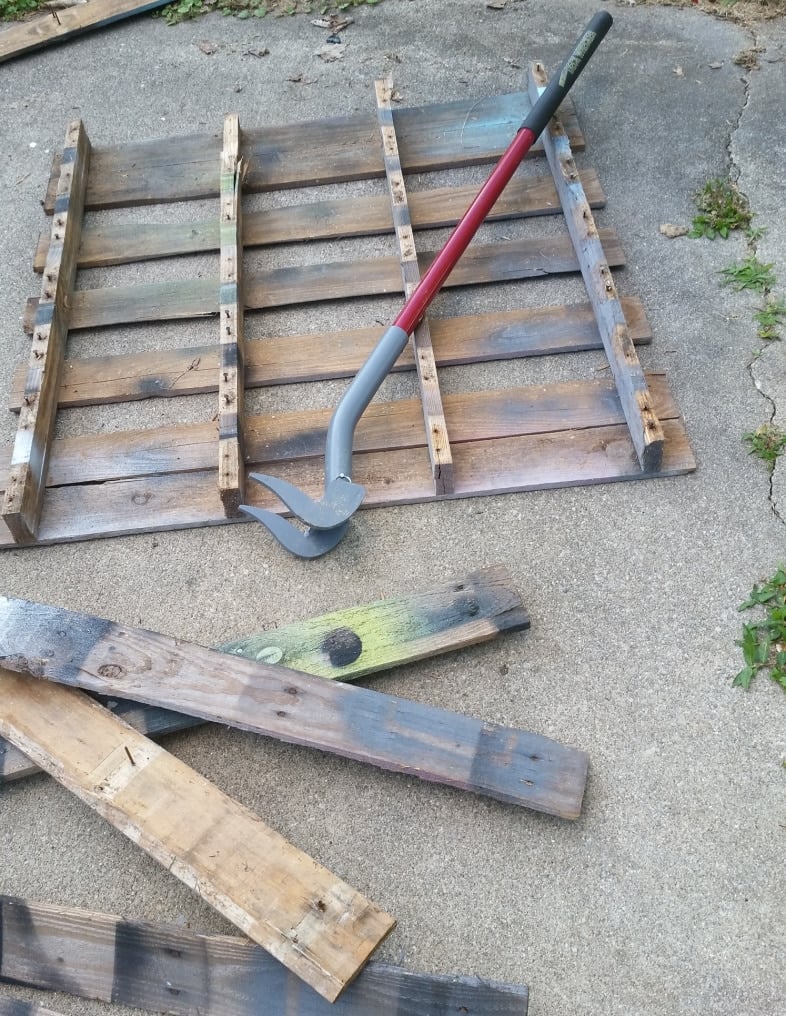 pallet dismantled with a duckbill deck wrecker-like a large crow bar