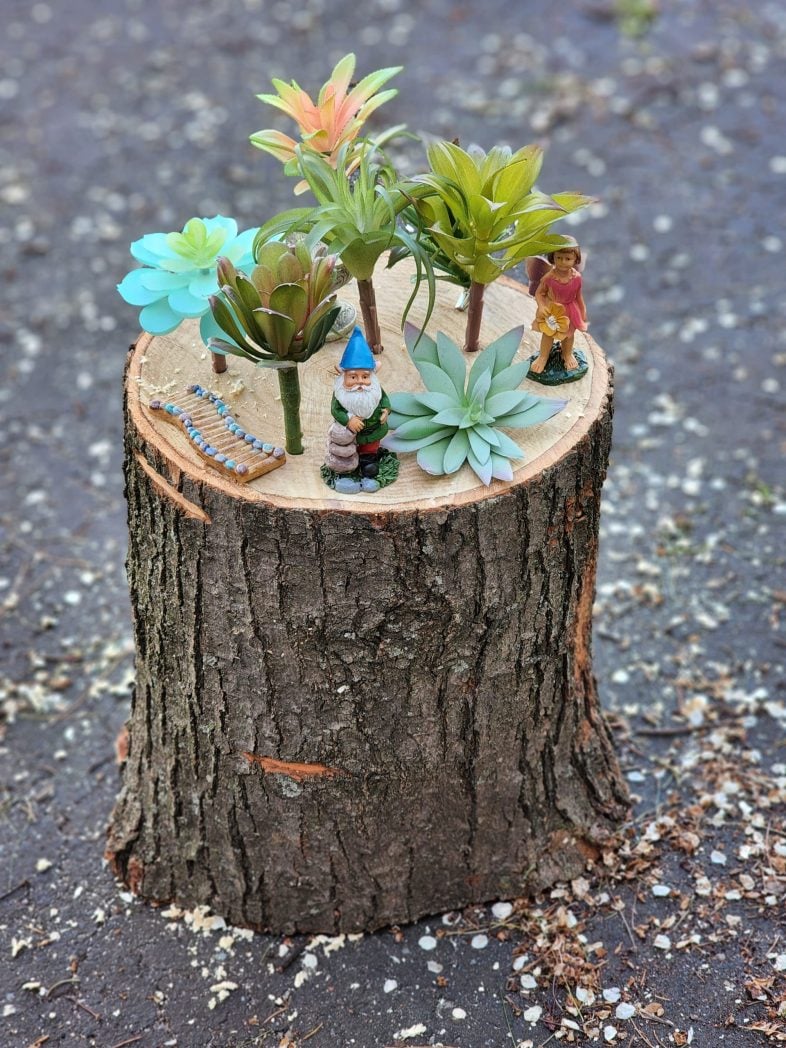 fairy garden pieces on a tree stump