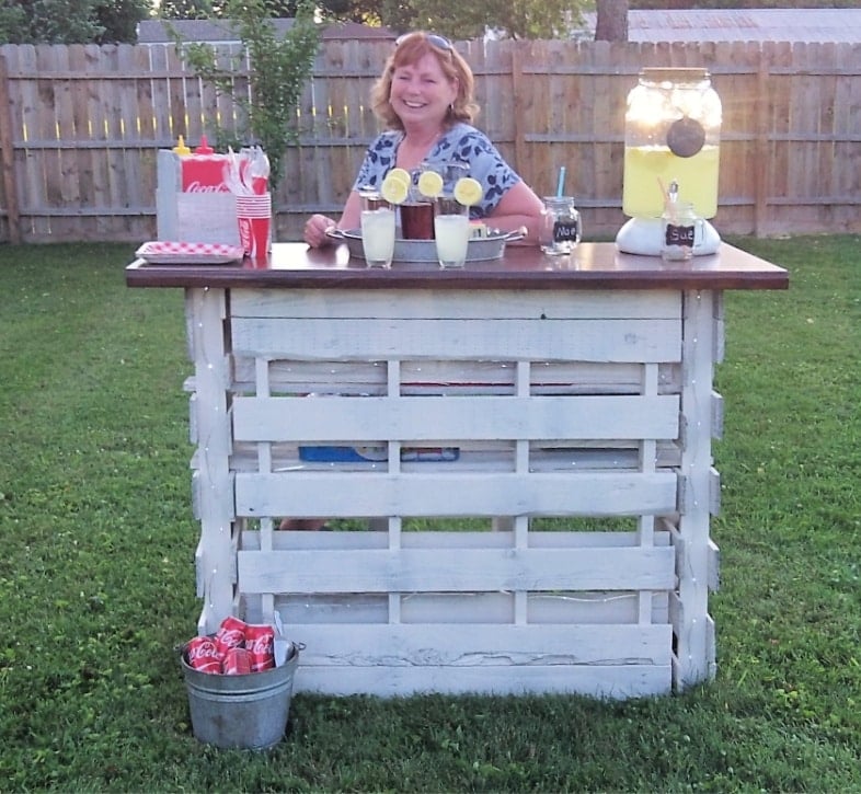 woman sitting at a folding pallet bar