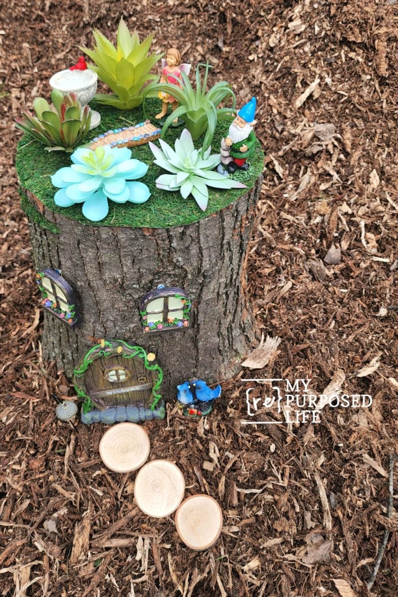 fairy garden tree stump with whimsical items 