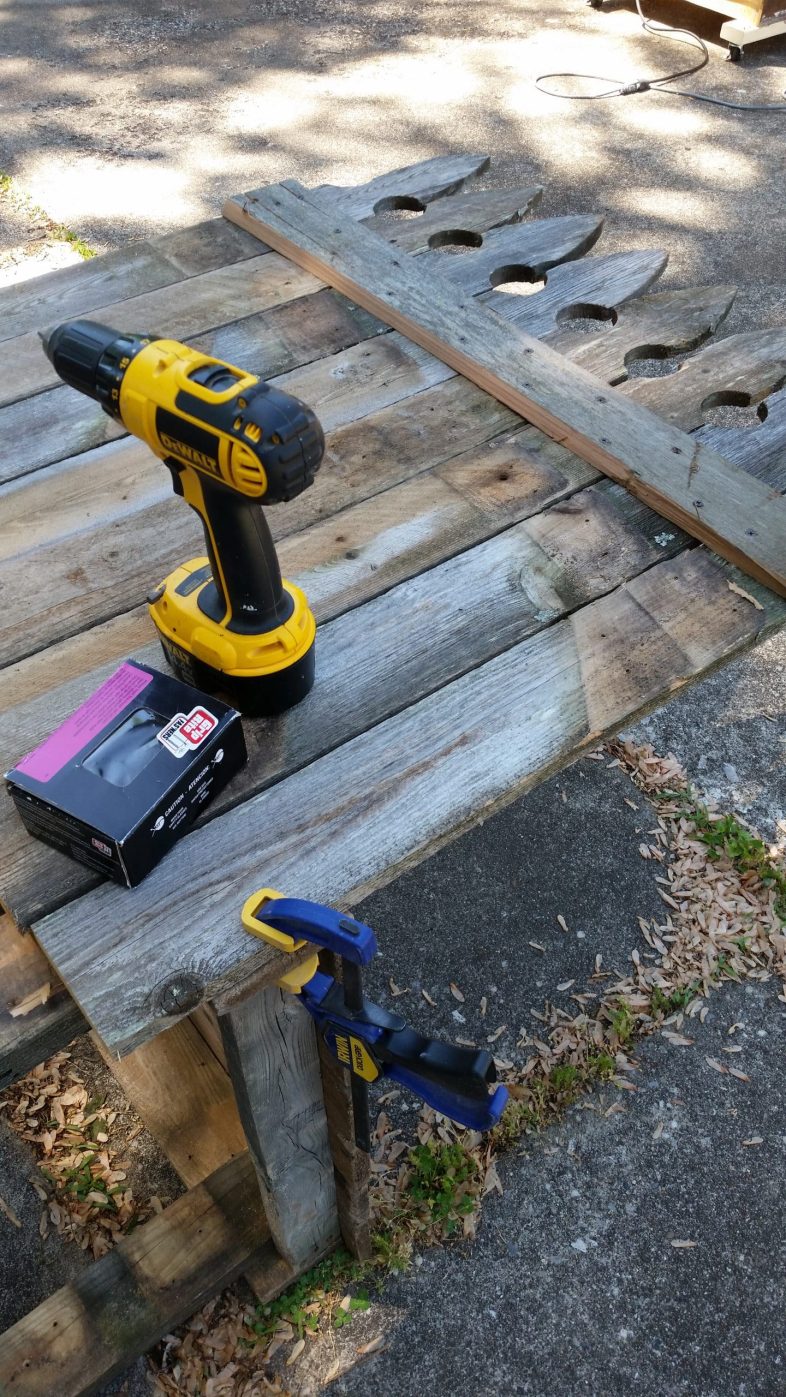 drill and screws resting on fence section