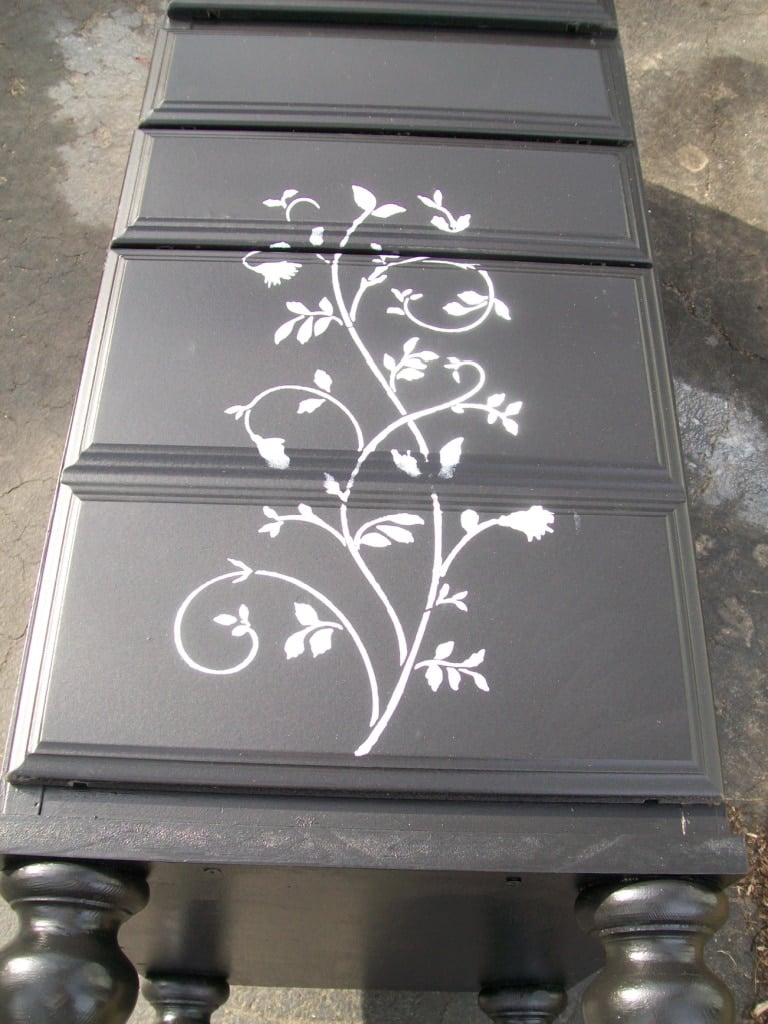 lingerie chest laying on its back with a floral stencil going up three drawers