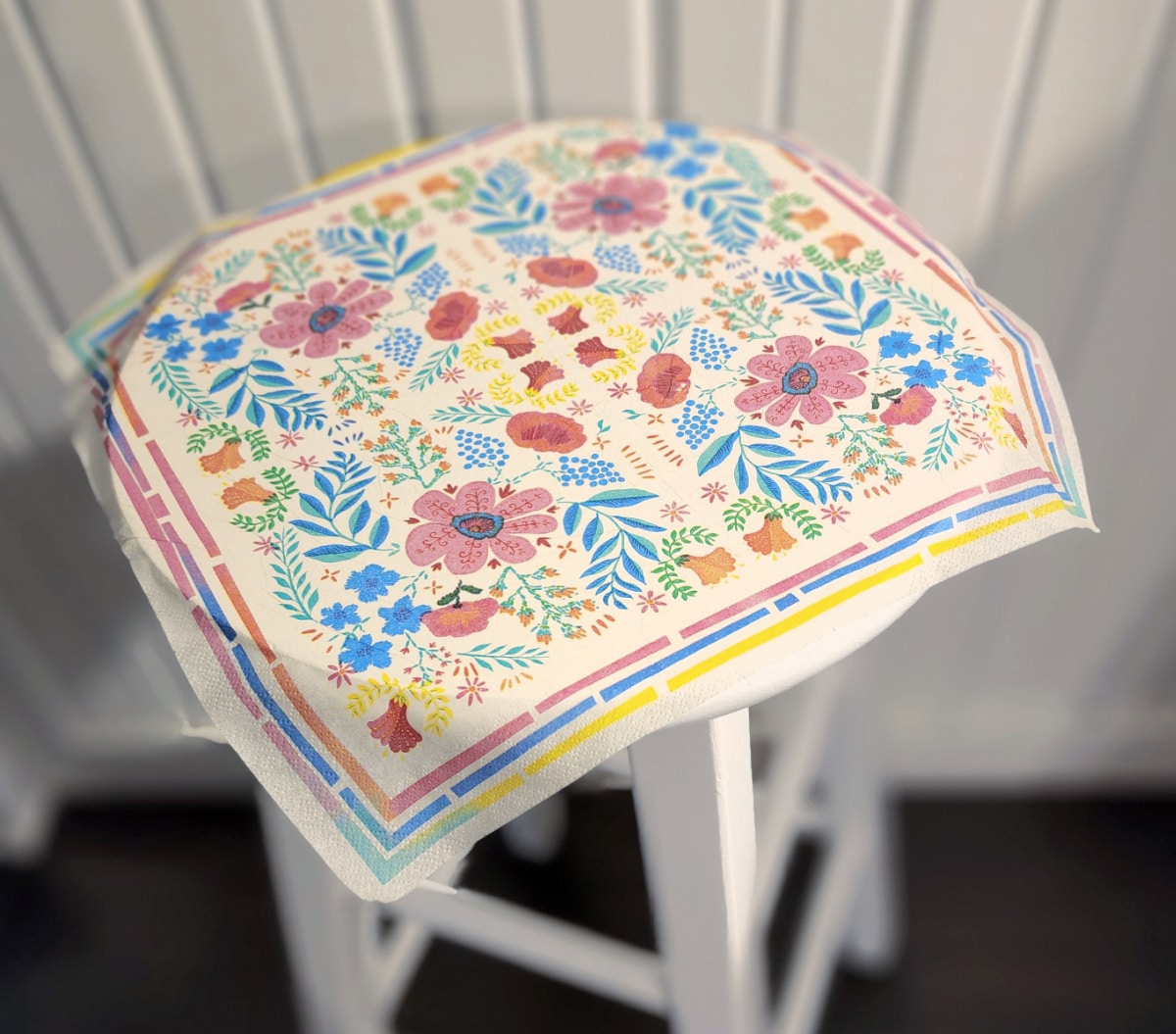 carefully lay a napkin on stool