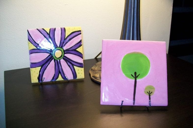 small tile coasters resting on curtain hook easels