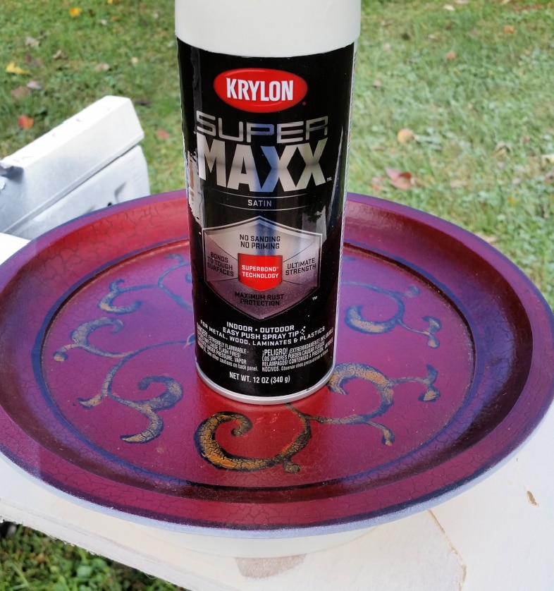 spray paint can resting on a red thrift store platter