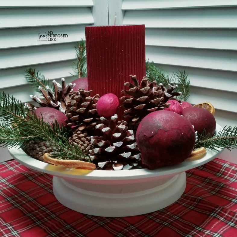 upcycled thrift store Christmas platter holding a candle with natural elements