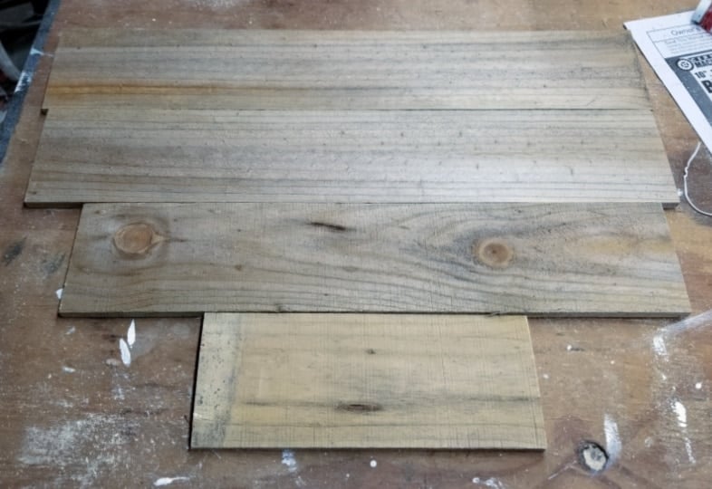 lay out scrap pieces of fence to make wooden heart