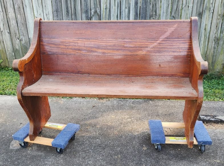 old church pew resting on furniture dollies