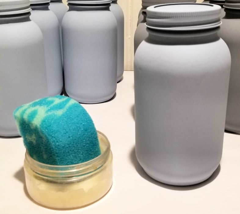 painted mason jars , a blue sponge in a jar of wax