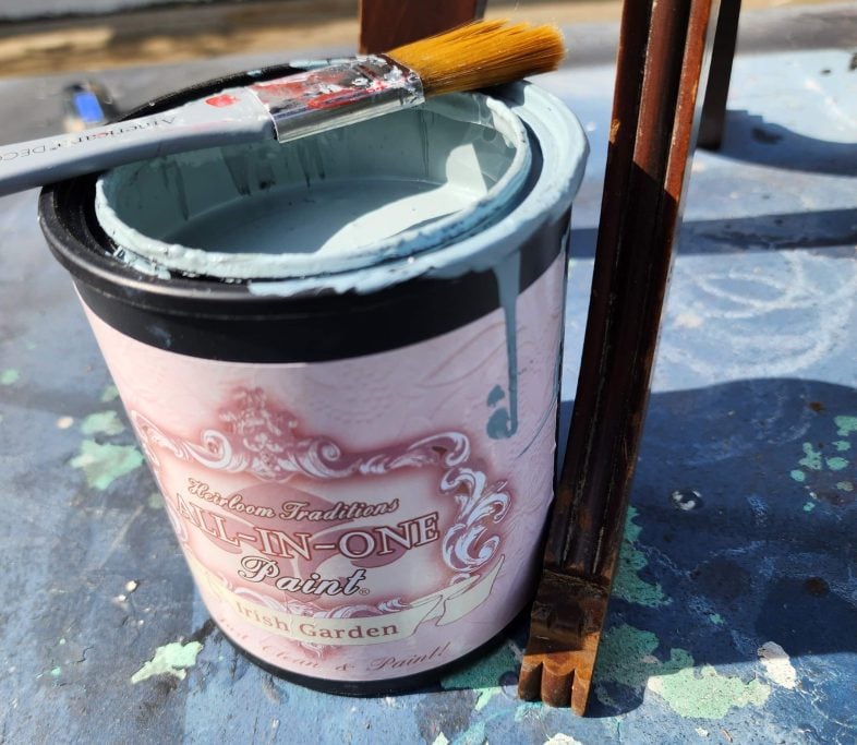 a can of blue paint with a paint brush