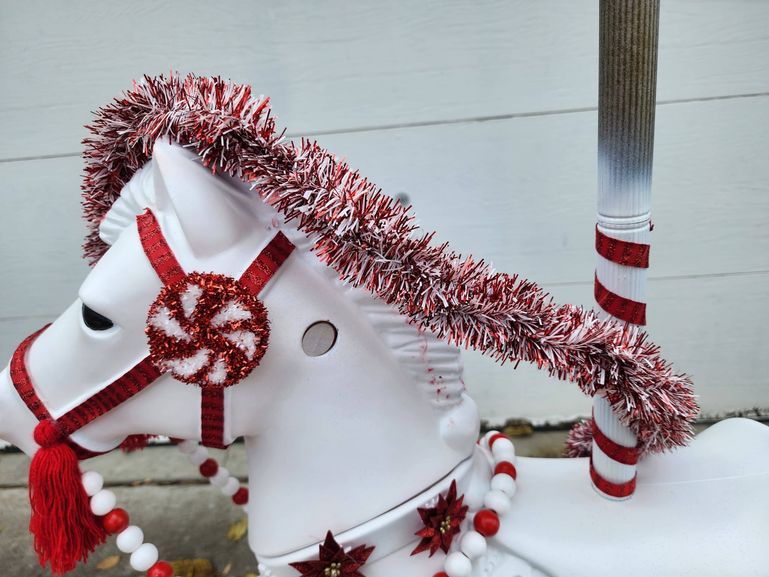 adding a garland mane to a Christmas carousel bouncy horse