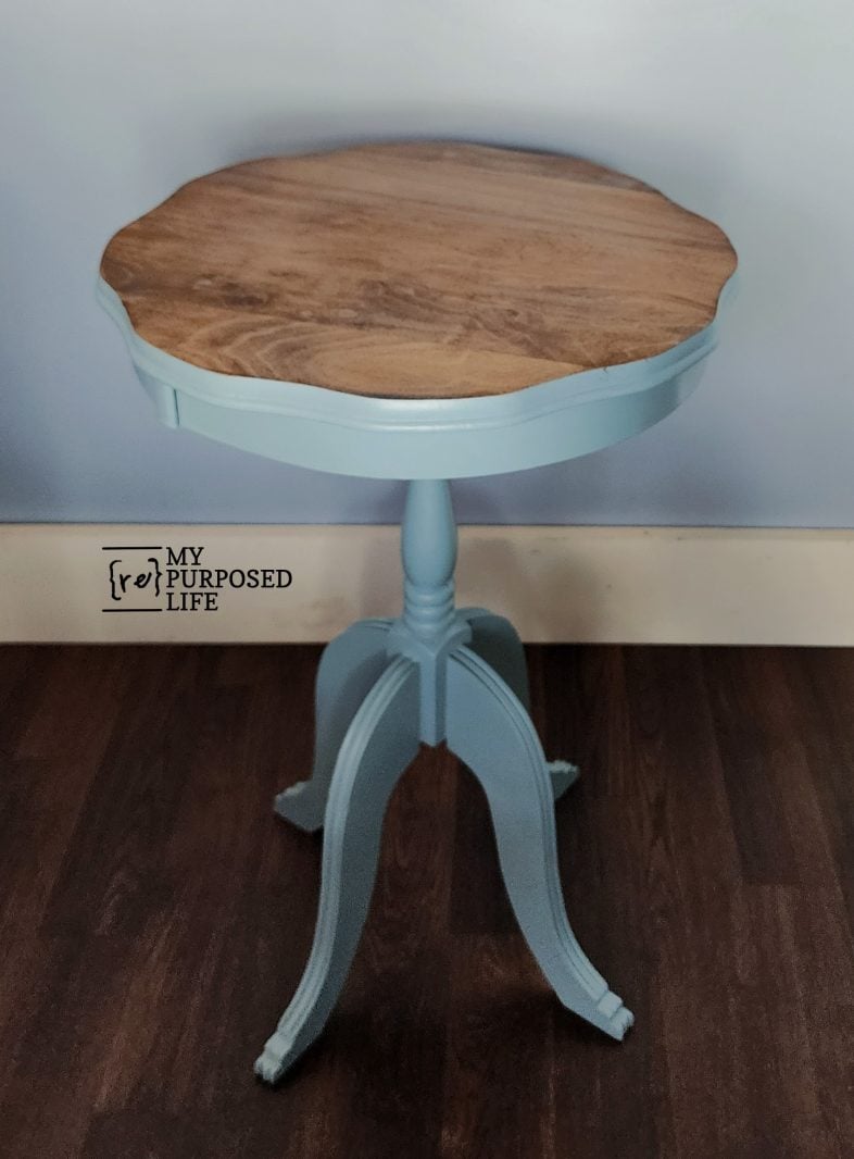 blue three-legged parlor side table with a stained top