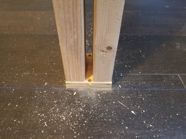 securing block of wood and closet frame to the floor