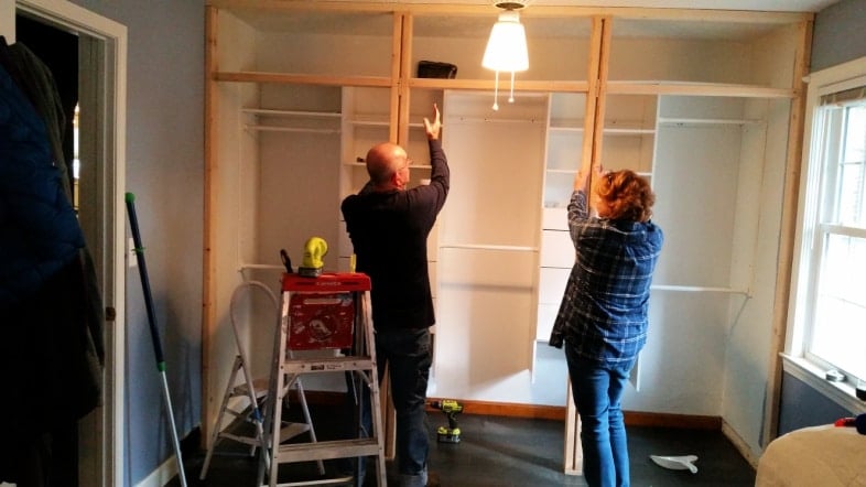 man and woman working on framing closet