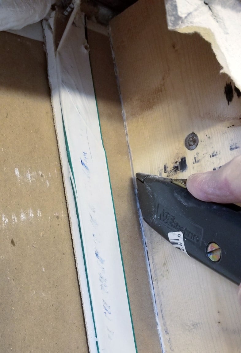 utility knife cuts away scrap drywall pieces for between the stud broom closet