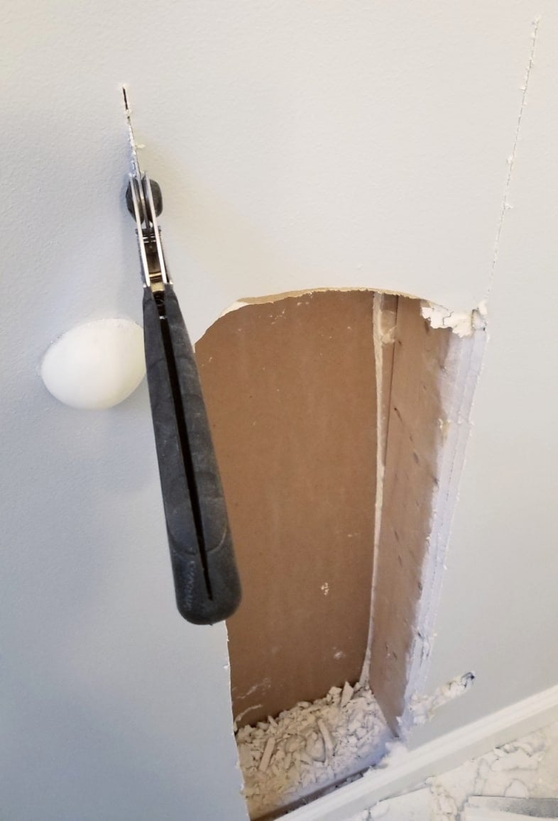 hole in the wall with a handsaw