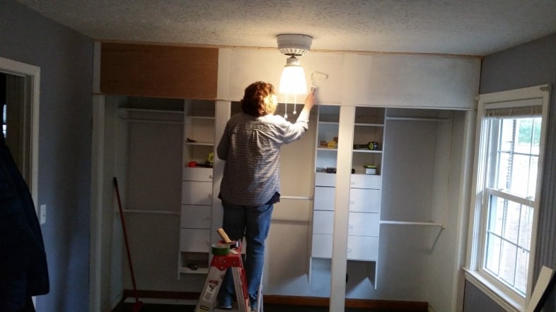woman painting header with small roller