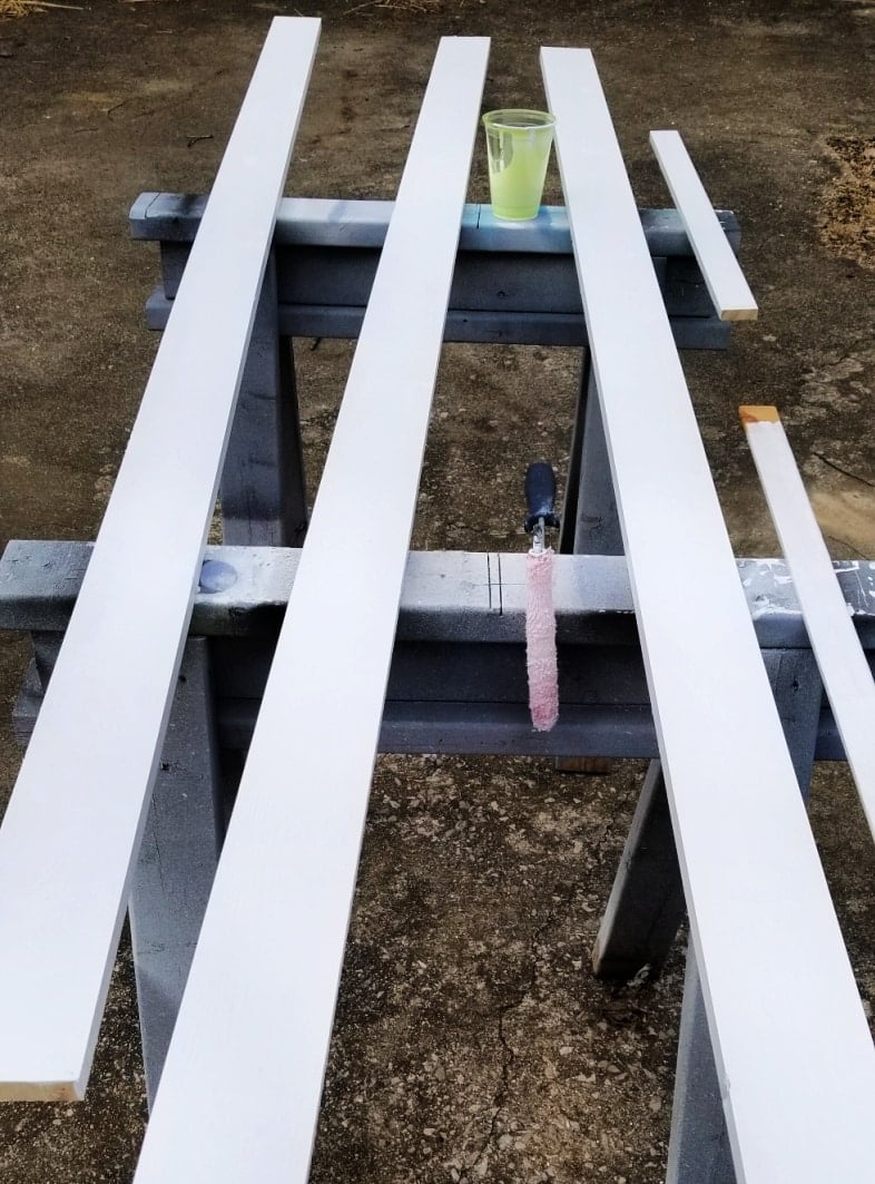 long boards that make up the insert being painted outdoors