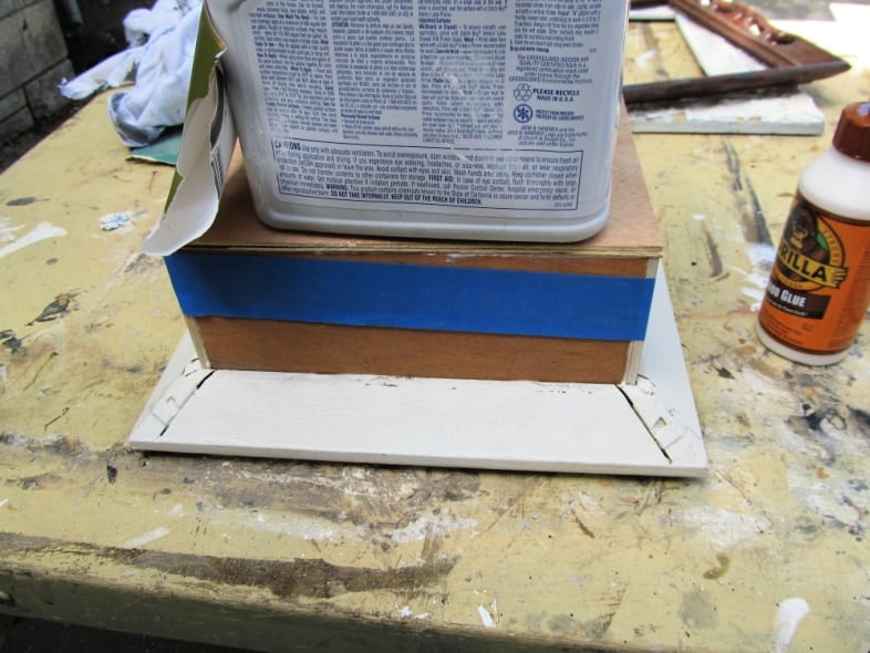 jug sitting on back of shadow box frame until glue sets up