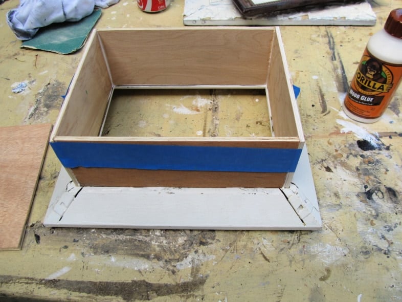 painter's tape wrapped around 4 pieces of shadow box frame