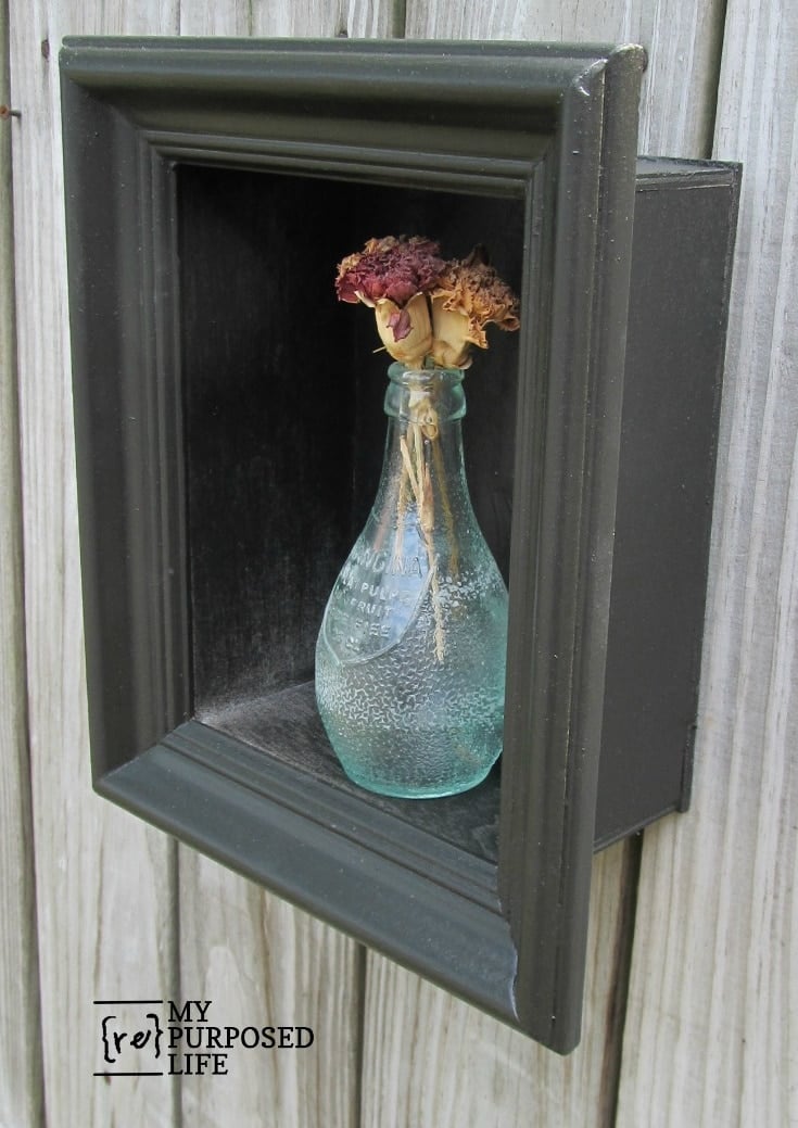 side vew of shadow box frame with glass vase and dried flowers