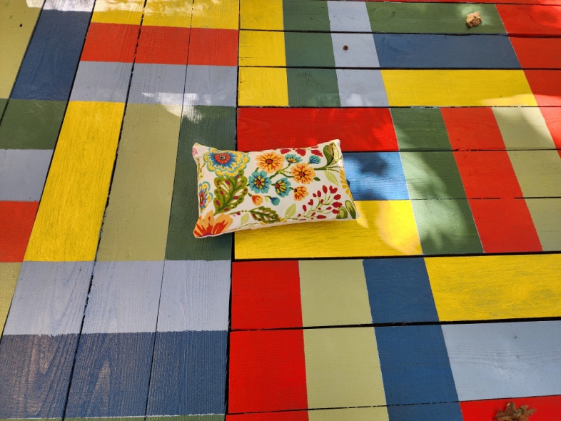 colorful pillow with matching colors of painted porch