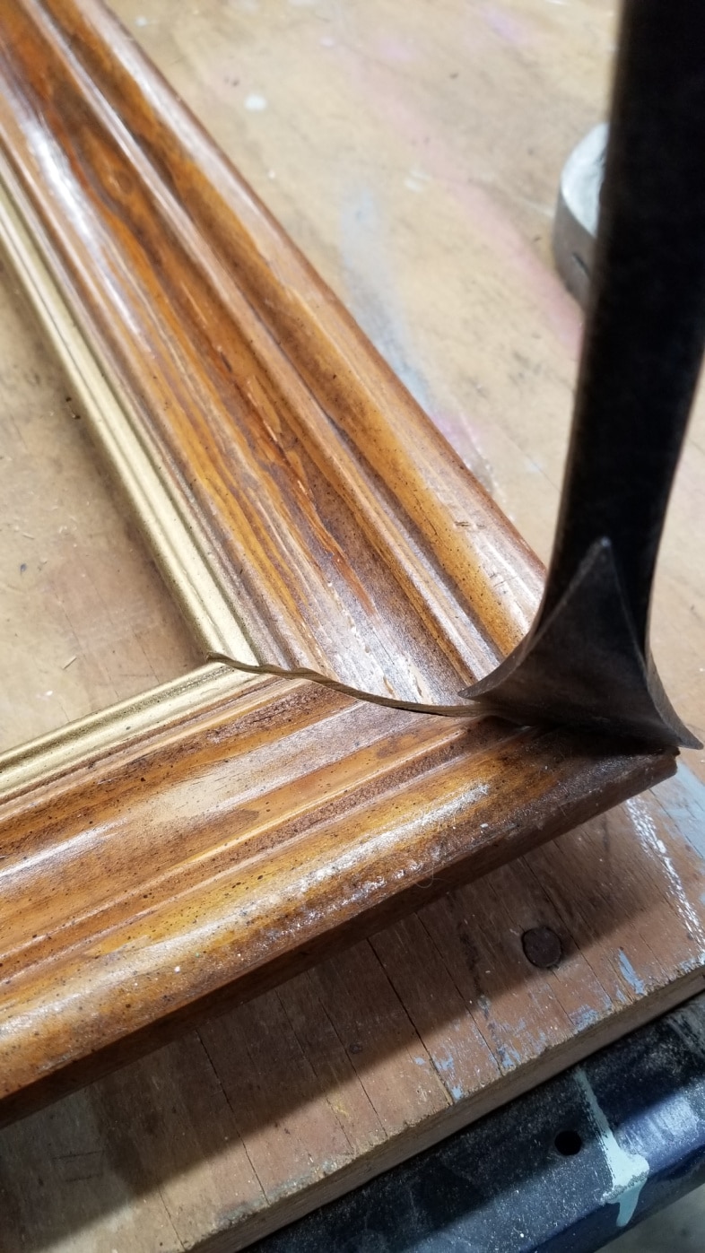 a pry bar separating a picture frame joing