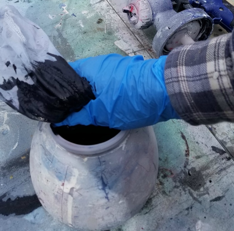 squeezing paint through a mesh strainer