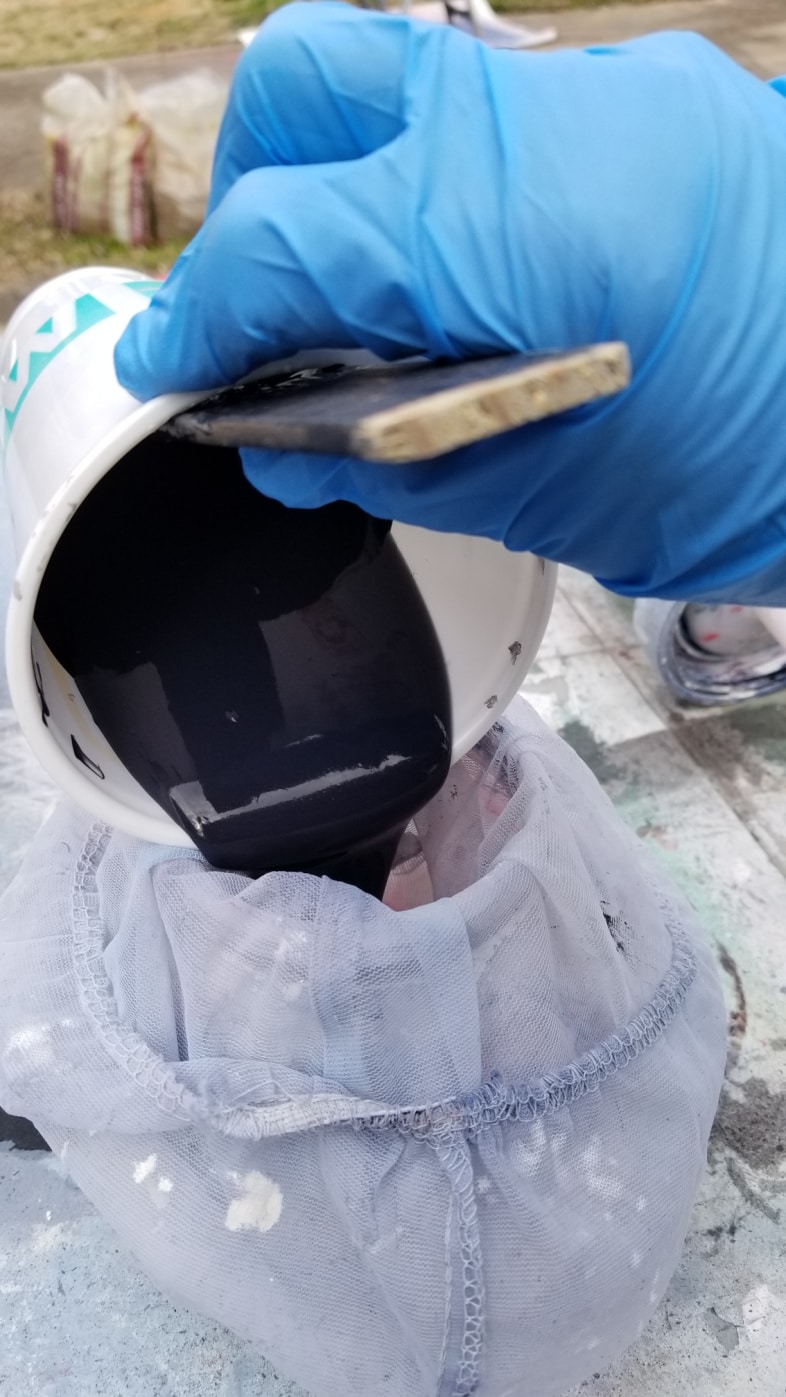 pouring paint into mesh strainer