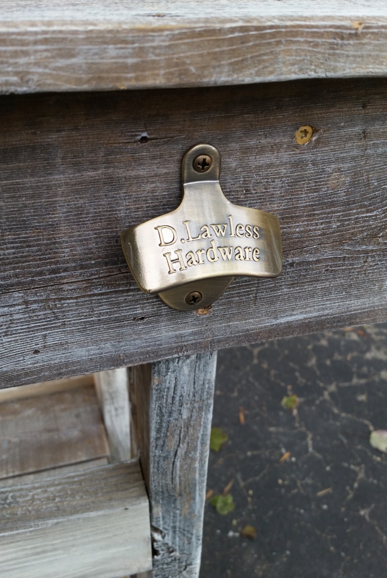 antique bronze bottle opener attatched to side of outdoor bar