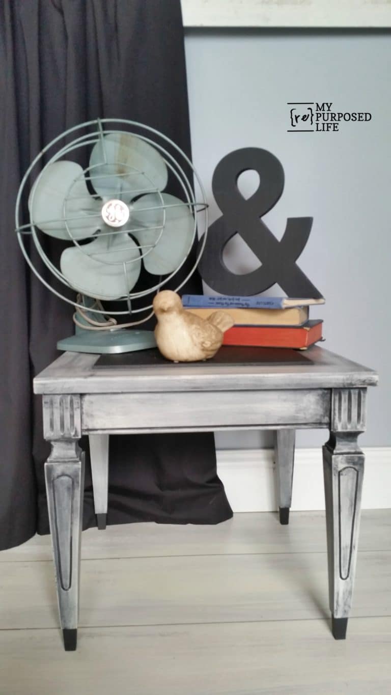 small side table with a blue fan resting atop
