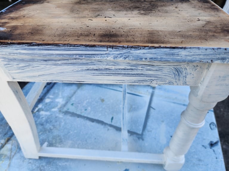 thin coat of white paint with wood showing through