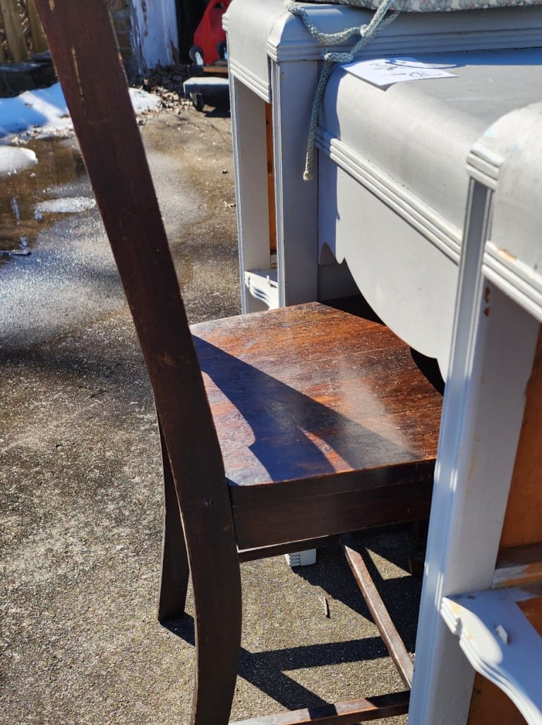 kitchen chair sitting at the kneehole of a desk