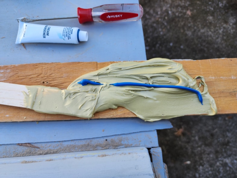 bondo filler and hardener spread on scrap wood