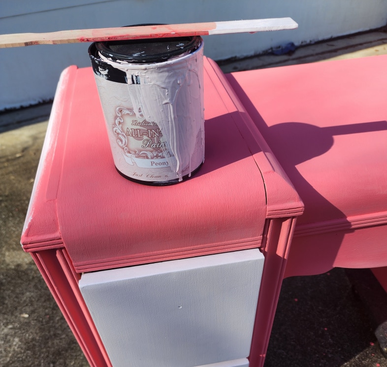 a can of light pink paint resting atop the bright pink vanity